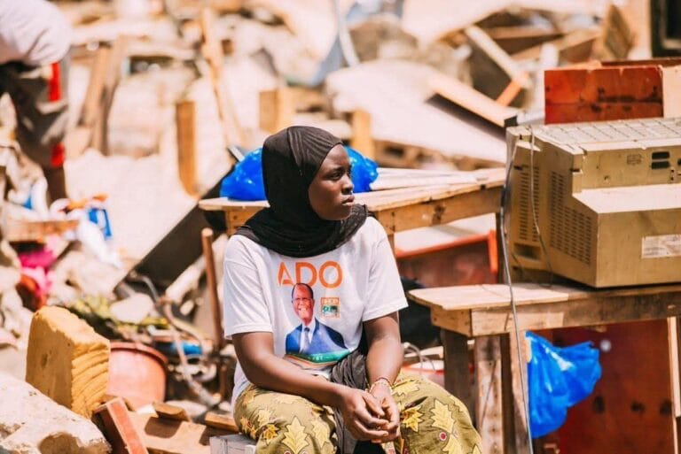 Jeune fille t-shirt ADO au milieu des décombres