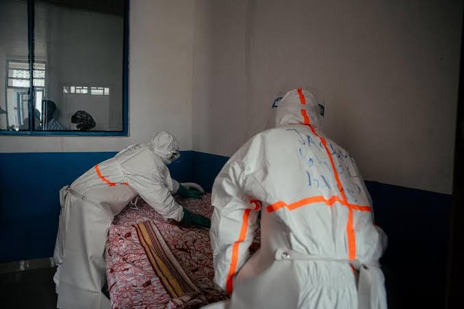 Personnels soignants en combinaison de protection biologique luttant contre la flambée d'Ebola dans un centre de traitement.