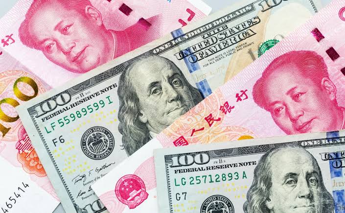 Billets de banque illustrant le recul du dollar face au yuan chinois sur une carte de l'Afrique.