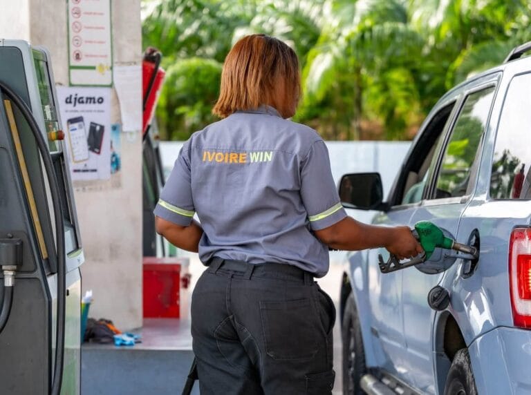Personnel souriant devant la station-service moderne Ivoire Win en Côte d'Ivoire.