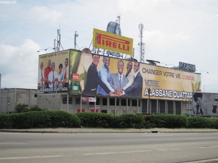 Opération de démantèlement de panneaux liés à la publicité à Abidjan sur la façade d'un grand immeuble.